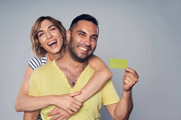 Casal feliz no estúdio rindo sobre cinza — Fotografia de Stock