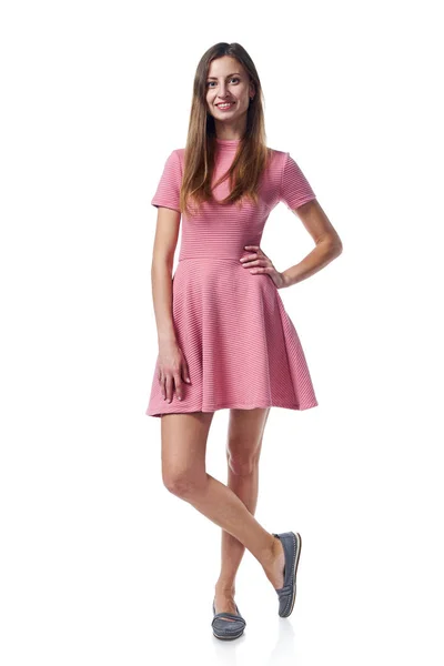 Full length of young woman in pink dress stadnign casually — Stock Photo, Image