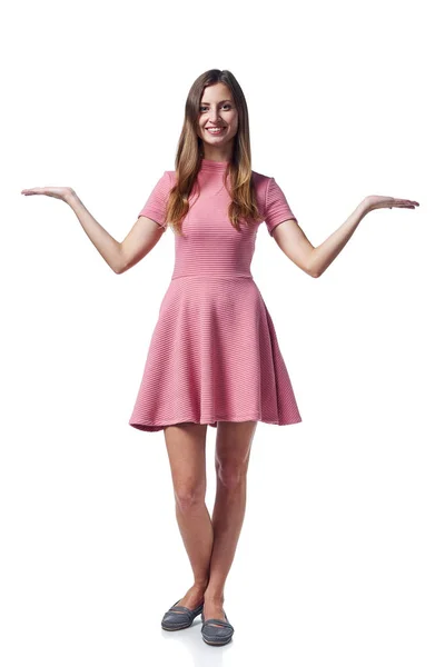 Kvinna i rosa klänning visar tomt kopieringsutrymme — Stockfoto