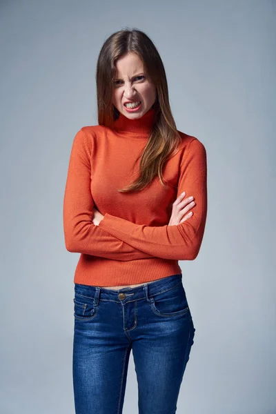 Mulher de jeans com expressão facial irritada — Fotografia de Stock