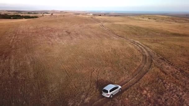 乾燥した土地を通って道路をオフに運転する車の航空写真 — ストック動画