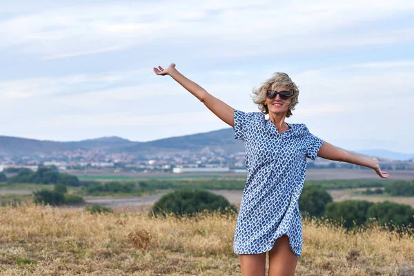 Happy woman enjoying outdoors with arms spreaded — Stock Photo, Image