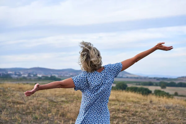 Mujer feliz disfrutando al aire libre con los brazos extendidos —  Fotos de Stock