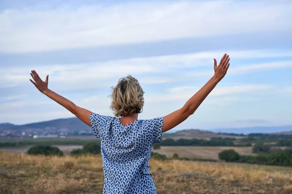 Mujer feliz disfrutando al aire libre con los brazos extendidos —  Fotos de Stock