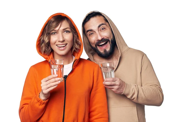 Молода пара в домашньому одязі зі склянкою води — стокове фото