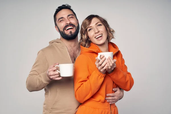 Pasangan bahagia berpakaian santai berdiri dengan cangkir teh — Stok Foto