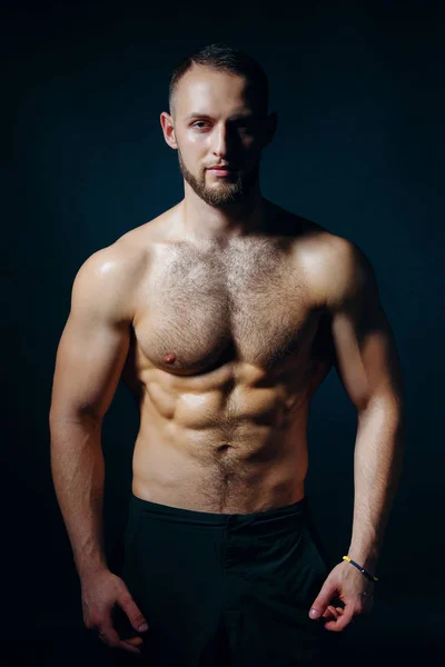 Low key portrait of muscular shirtless man at dark background — Stock Photo, Image