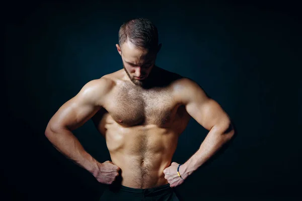 Baixo retrato chave do homem sem camisa muscular no fundo escuro — Fotografia de Stock