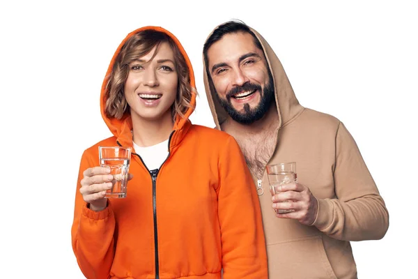 Молода пара в домашньому одязі зі склянкою води — стокове фото