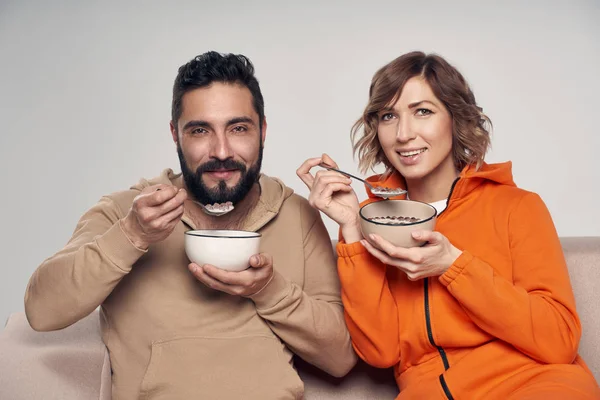 Pasangan dalam pakaian santai makan jagung serpih dengan susu — Stok Foto