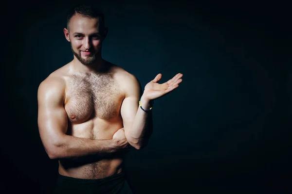 Hombre musculoso sin camisa sosteniendo un espacio de copia vacío en la palma abierta de la mano que se muestra en el espacio de copia en blanco — Foto de Stock