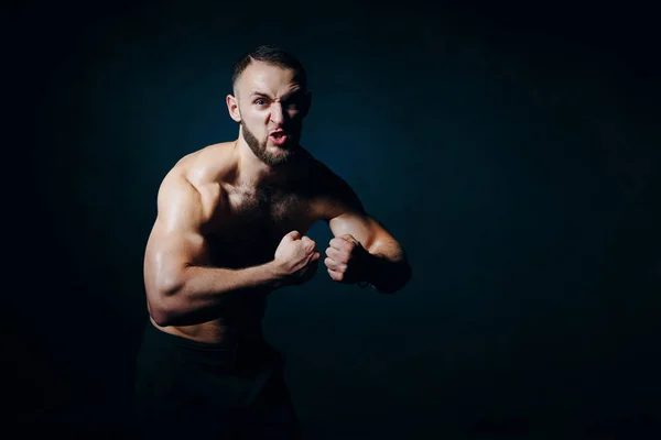 Low key portrait of muscular shirtless man at dark background — Stock Photo, Image