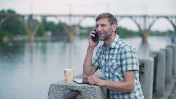 Dospělý muž na řece a mluví v mobilním telefonu — Stock video