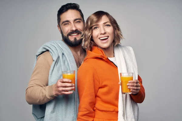 Молода пара в повсякденних окулярах апельсинового соку — стокове фото