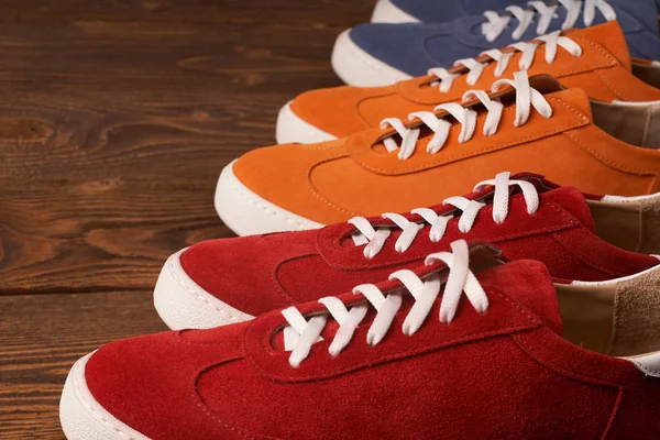 Top view of casual colorful suede trainers on wooden planks — Stock Photo, Image