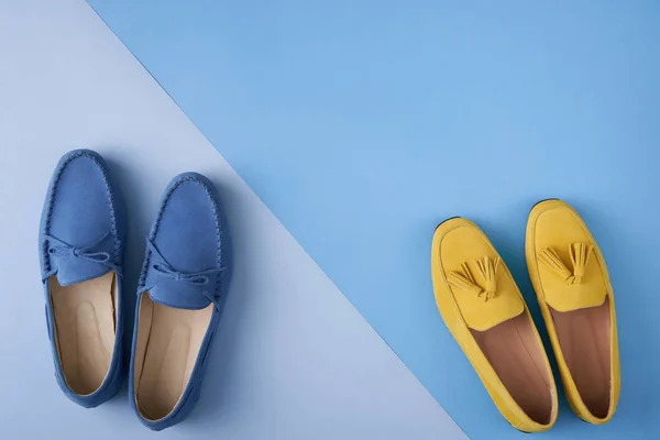 Blue suede man's and yellow woman's moccasins shoes over blue background — Stock Photo, Image