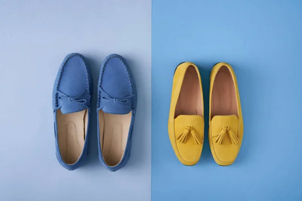 Blue suede man's and yellow woman's moccasins shoes over blue background — Stock Photo, Image