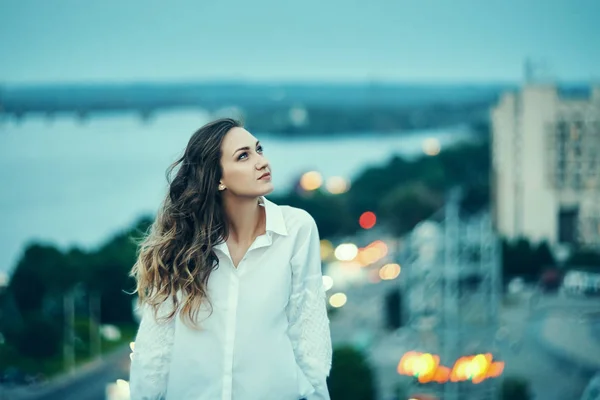 Young woman over cityscape looking up at sky — 스톡 사진