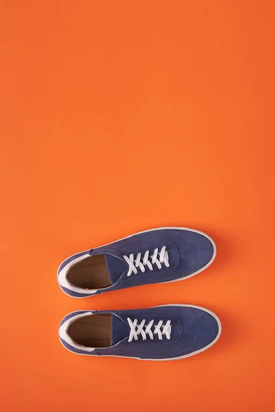 오렌지 색 배경의 캐주얼 블루 스웨이드 스니커즈 탑 뷰 — 스톡 사진
