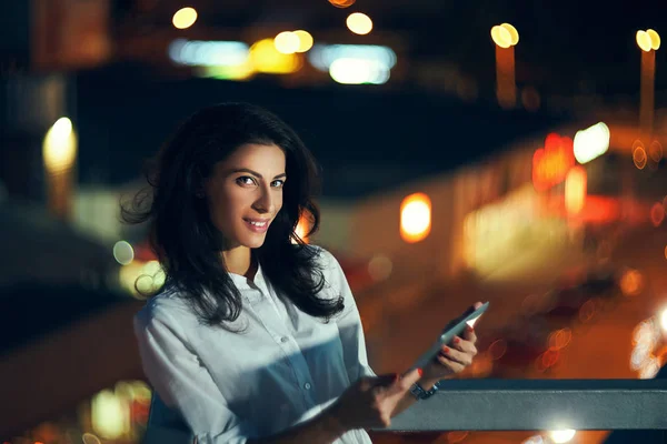 デジタルタブレットのテキストメッセージを保持する夜の都市景観上の女性 — ストック写真