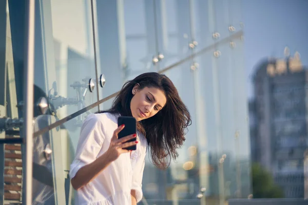 現代のオフィスのブイディングの上に彼女のスマートフォンで自己ポートレートを作る女性 — ストック写真