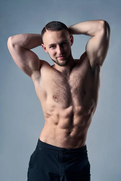 Muscular shirtless man posing with hands over head — Stock Photo, Image