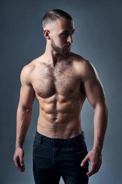 Muscular shirtless man standing with hands in pockets — Stock Photo, Image