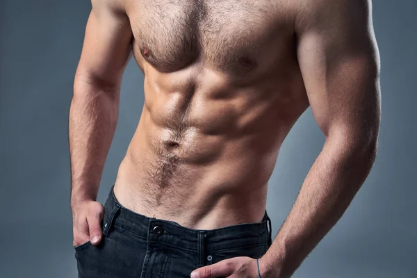 Cropped image of muscular shirtless with hands in pockets — Stock Photo, Image