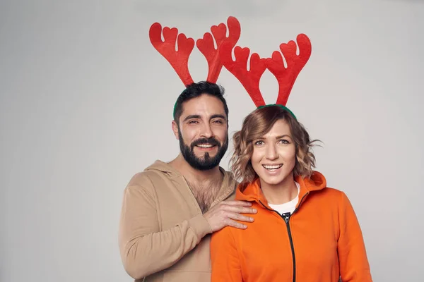 Щаслива усміхнена пара в костюмах різдвяних оленів посміхається — стокове фото