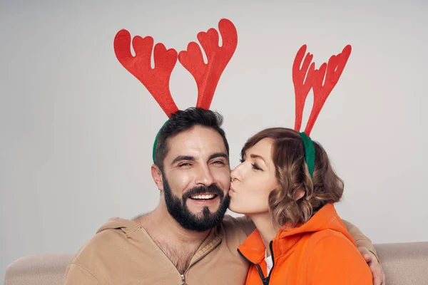Feliz pareja sonriente vistiendo trajes de venado navideños sonriendo —  Fotos de Stock