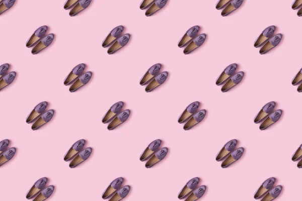 ピンクの背景にライラックスエードモカシンシューズのパターン — ストック写真