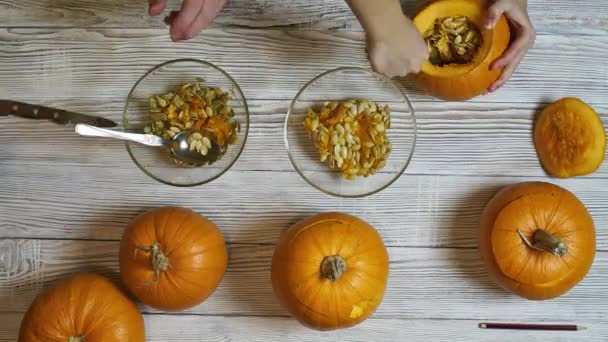 Top view timelapse video di adulti e bambini mani intaglio jack-o-latern da zucche — Video Stock