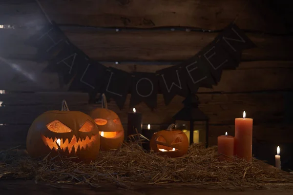 Jack-O-Lantern Хеллоуїн гарбузи на грубих дерев'яних дошках зі свічками — стокове фото