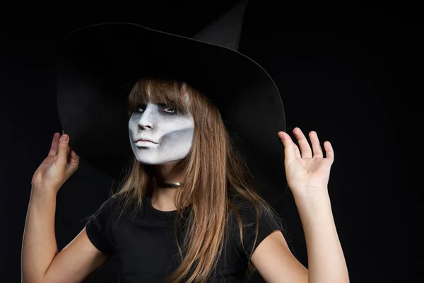 Close-up van Halloween heks meisje kijken naar camera op zwarte achtergrond. — Stockfoto