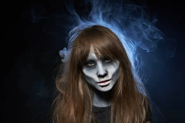 Девушка с зомби макияжем на темном фоне с дымом и подсветкой — стоковое фото
