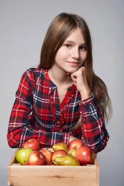 Adolescente chica con manzanas y peras en una caja —  Fotos de Stock