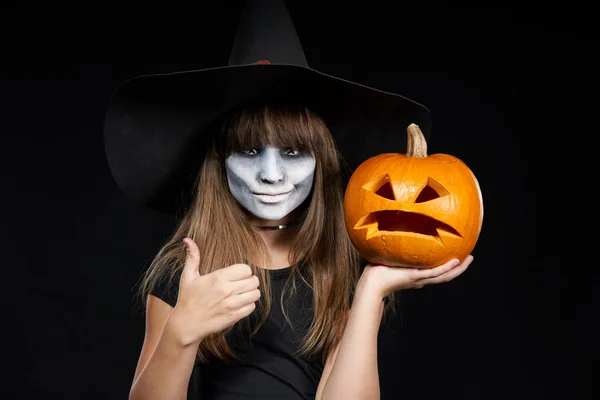 Halloween häxa flicka som visar Jack-O-Lantern pumpa på Palm — Stockfoto