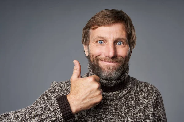 Vzrušený dospělý muž v teplém svetru dává palec nahoru — Stock fotografie