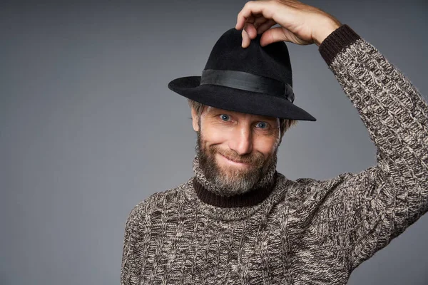Senyum pria dewasa dalam sweater hangat mengangkat topinya salam — Stok Foto