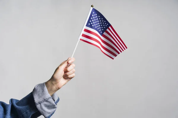 Menselijke hand die de Amerikaanse vlag vasthoudt — Stockfoto