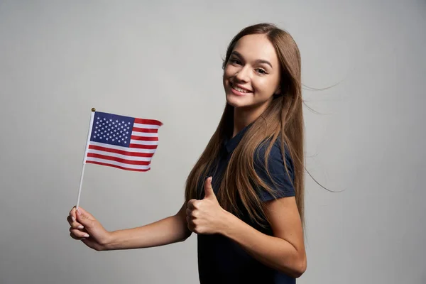 Happy female holding USA flag and gesturing thumb up — Stock Photo, Image