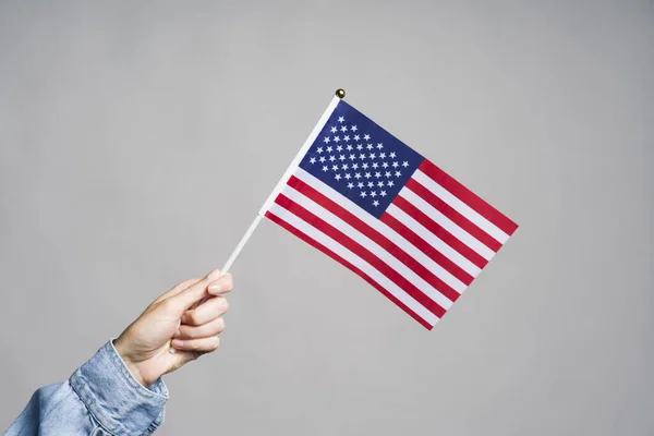 Mão humana segurando bandeira dos EUA — Fotografia de Stock