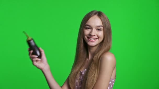 笑顔の女の子身に着けている夏のドレス笑顔と保持ナス 隔離された緑のクロマキーの背景 — ストック動画