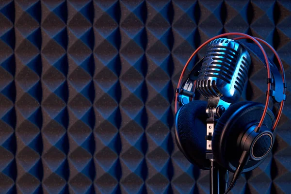 声泡沫面板背景图带专业耳机的演播室冷凝器麦克风 — 图库照片