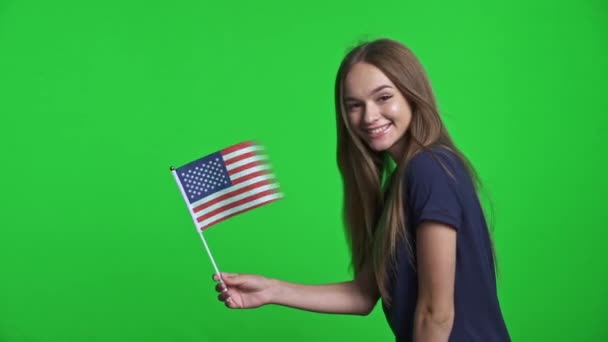 Sonriente chica sosteniendo bandera de EE.UU. ondeando en el viento — Vídeo de stock