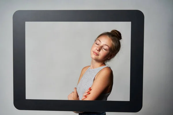 Gadis cantik yang berdiri di belakang bingkai tablet digital menikmati dengan mata tertutup — Stok Foto