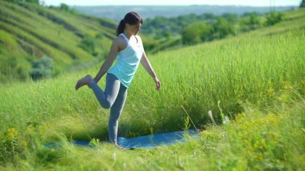 Giovane donna che fa yoga nel prato verde estivo — Video Stock