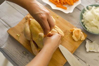 Ahşap kesme tahtası, çiğ tavuk hazırlama eller yakın çekim 