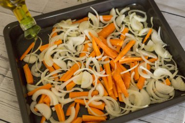 Zeytinyağı plaka soğan ve havuç dilimleri ile pişirme hırıltı