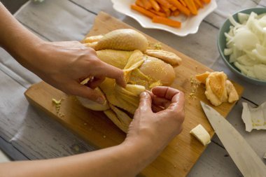 Ahşap kesme tahtası, çiğ tavuk hazırlama eller yakın çekim 